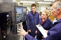 Engineer Teaching Apprentices To Use Computerized Lathe