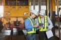 Engineer team work service maintenance diesel train at railway depot looking locomotive plan in tablet digital technology device