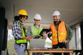 Engineer teams meeting working together wear worker helmets hardhat on construction site in city. industry professional team Royalty Free Stock Photo