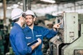Engineer teamwork checking control panel and teaching new worker to operating control the machine in factory Royalty Free Stock Photo