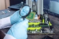 Engineer technician computers in gloves on the hands is reviewing the failure. Concept of repair microchip Royalty Free Stock Photo