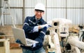 Engineer technician controlling robotic arms on computer laptop Royalty Free Stock Photo