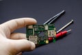 An engineer technician holds a chip and tools for repairing electronic gadgets on a black background. Repair of mobile phones Royalty Free Stock Photo