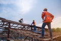 Engineer technician watching team of roofer working on roof structure of building in construction site, Roof metal sheet