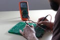 Engineer test electronic component with multimeter