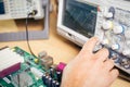 Engineer tests electronic components with oscilloscope in the service center