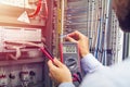 Engineer tests industrial electrical cabinet. Wire in hand of electrician with multimeter. Professional in control panel