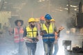 Engineer in uniform and helmet using tablet computer at factory. Worker with safety helmet checking quality in manufacturing Royalty Free Stock Photo