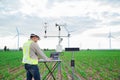 Engineer using tablet computer collect data with meteorological instrument to measure the wind speed, temperature and humidity and