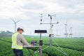 Engineer using tablet computer collect data with meteorological instrument to measure the wind speed, temperature and humidity and