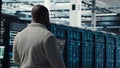Engineer walking in server farm, automating system diagnostics Royalty Free Stock Photo