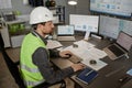 Engineer wearing hardhat at workplace in office and using computer