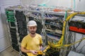 The engineer in a white helmet measures the level of the optical signal in the server room of the data center. A technician