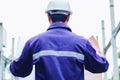 Engineer with white safety helmet holding project plan at construction outdoor site background Royalty Free Stock Photo