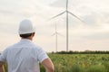 Engineer in a wind turbine. A man in a helmet supervises the operation of the electric windmills. Ecology and renewable energy