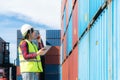 Engineer woman or Foreman manager in container depot working with digital tablet and walkie talkie for control and checking