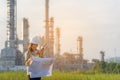 Engineer woman holding blueprint with radio for workers security control at power plant energy and petrochemical industry Royalty Free Stock Photo