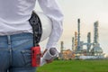 Engineer woman holding white helmet and blueprint with radio for workers security control at power plant Royalty Free Stock Photo