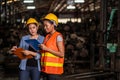 Engineer woman standing at the warehouse where keep the old machine parts. Both of them wearing a safety helmet and holding