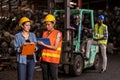 Engineer woman wearing helmet standing at the large warehouse where keep machine parts and holding clipboard. Used of vehicle part