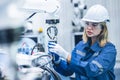 engineer woman worker working with robotic arm in productions lab research industry factory