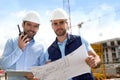 Engineer and worker checking plan on construction site Royalty Free Stock Photo