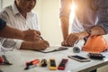 Engineer working at a blueprint of house in office for discussing real estate project. Engineering tools and construction concept Royalty Free Stock Photo