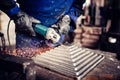 Engineer working on cutting a metal and steel bar with angle grinder, metallurgic factory details