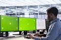 Engineer working at multi monitor chroma key PC in server farm Royalty Free Stock Photo