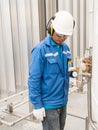 Engineer working with safety ear muffs helmet and gloves for ind