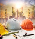 Engineer working table plan, and oil refinery plant in heavy pet Royalty Free Stock Photo