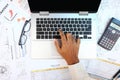 Engineer working using laptop with project documents, schedule, eyeglasses and calculator Royalty Free Stock Photo