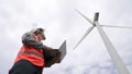 Progressive engineer working with the wind turbine, with the sky as background. Royalty Free Stock Photo