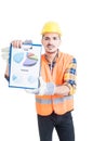 Engineer in workwear and halmet holding a clipboard with charts