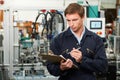 Engineer Writing On Clipboard In Factory