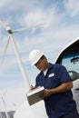 Engineer Writing On Clipboard At Wind Farm