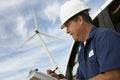 Engineer Writing On Clipboard At Wind Farm