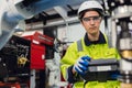 Engineer young man university student learn to control operate industry robot welding arm in robotics engineers lab classroom in