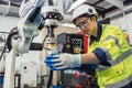 Engineer young man university student learn to control operate industry robot welding arm in robotics engineers lab classroom in