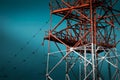 National Energy Grid system. Power pylons connecting the country. Red steel structures on deep blue sky