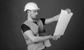 Engineering concept. Engineer, architect, labourer, builder on strict face holds old blueprint in hands. Man, handyman Royalty Free Stock Photo