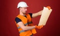 Engineering concept. Engineer, architect, labourer, builder on strict face holds old blueprint in hands. Man, handyman Royalty Free Stock Photo