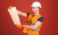 Engineering concept. Engineer, architect, labourer, builder on strict face holds old blueprint in hands. Man, handyman Royalty Free Stock Photo