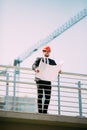 Handsome man Engineering Consulting people on construction site holding blueprint in his hand. Building inspector. Construction si