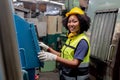 Engineering female African American happy smiling workers wear soundproof headphones and yellow helmet.