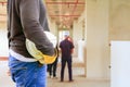 Engineering hand holding white safety hat interior renovate house working construction site Royalty Free Stock Photo