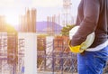 Engineering hand holding white safety hat interior working construction site in building Royalty Free Stock Photo