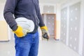 Engineering hand holding white safety hat working interior gypsum renovate house Royalty Free Stock Photo