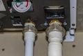 Engineering heating systems for houses. Close-up of gas boiler piping nodes with ball valves and pressure gauge.