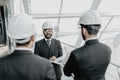 Engineering indian men with paper and hardhat working indoors in building . Team of architects working together on business plan. Royalty Free Stock Photo